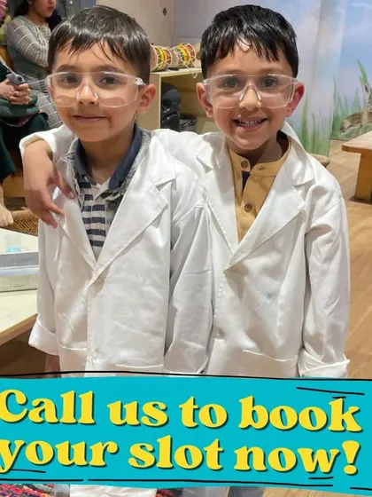 Two proud scientists give a thumbs-up. The lab coats and goggles make them feel like real professionals.