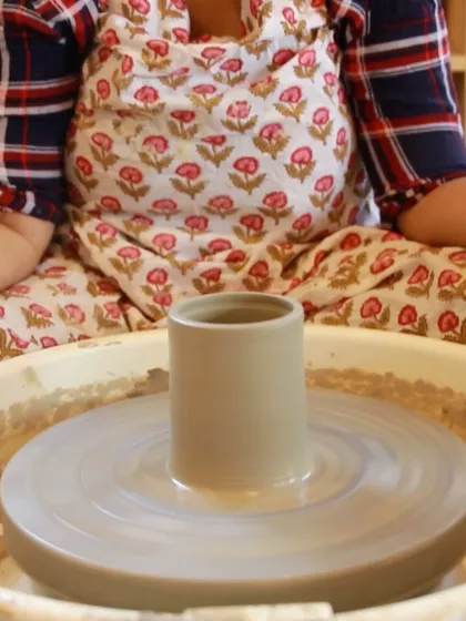 A perfectly centered and thrown cylinder sits on the wheel, a testament to a student's progress in our weekend course.