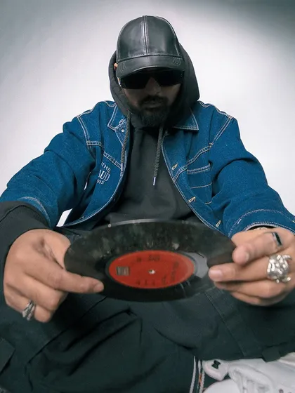 A direct, confident pose holding a classic 45 record. My style is a tribute to the foundations of hip hop.