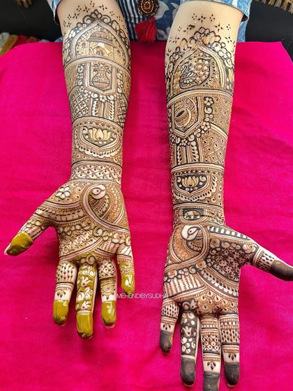 A clear shot of the same bridal henna against a pink background, highlighting the symmetry and detail.