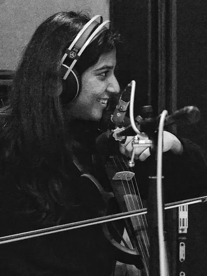 A smiling shot of Apoorva Krishna on violin. Her beautiful playing is an essential part of the 'VARI' sound.