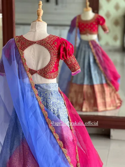 A mirror reflection captures the full ensemble, highlighting the playful yet traditional design of this kids' half-saree.