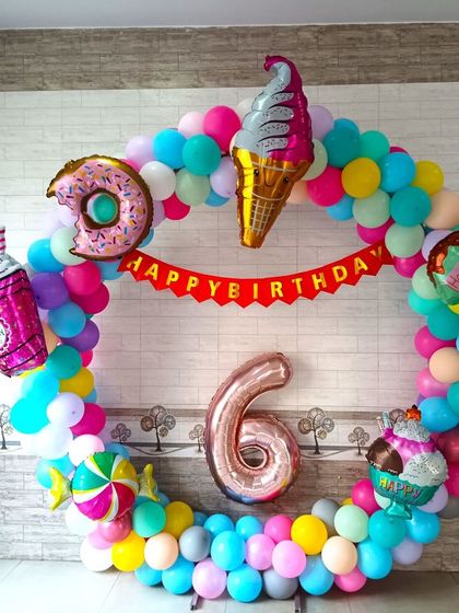 A fun donut and candy themed 6th birthday balloon ring. The colorful ring is decorated with various sweet treat foil balloons.