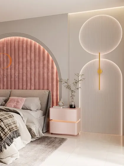A modern bedroom design featuring a striking arched headboard with pink velvet channel tufting. The space is enhanced by custom backlit wall panels and a matching bedside table, creating a soft, luxurious, and contemporary ambiance.