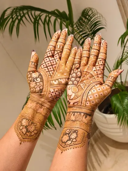 A gorgeous bridal design featuring a mix of royal elements. One hand has a beautiful peacock, while the other has a majestic elephant, both surrounded by jaali patterns.