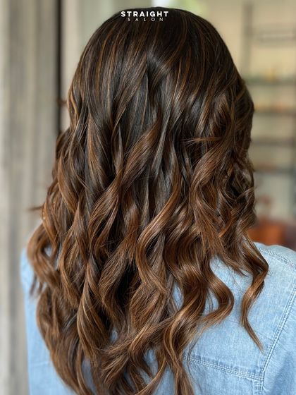 Another angle of the golden-toned balayage, showing the full length and volume.