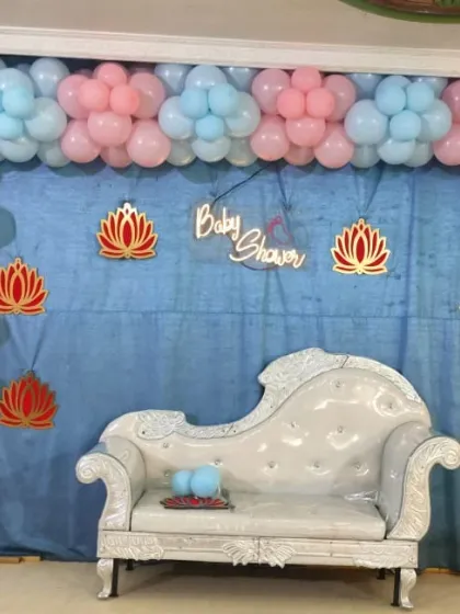 This baby shower setup features a 'Baby Shower' neon sign, adding a trendy touch to the pastel balloon backdrop and elegant seating.