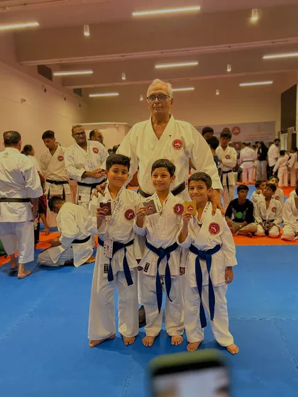 A group of young blue belts with their medals and their Sensei. Their first tournament is just the beginning of a long and rewarding journey.
