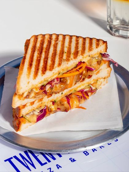 A beautifully composed shot of the Togarashi Chicken Melt, ready to be enjoyed with an iced coffee.