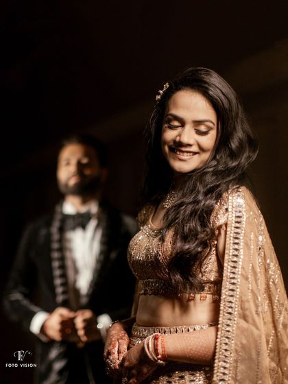 A creative portrait with the bride in focus and the groom smiling in the background. This composition tells a story and adds depth to the couple's gallery.