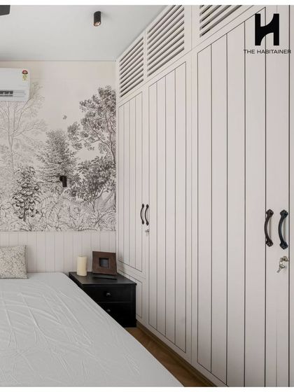 A closer look at the master bedroom's custom wardrobe. The white, vertically grooved doors with classic black handles provide ample storage while complementing the room's French-inspired aesthetic.