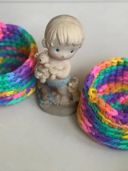 These colorful baskets are a must-have for any room. Here they are styled with a small figurine, showing their decorative potential.