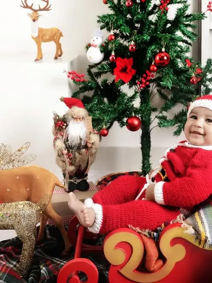 Capturing the pure joy of the holiday season with a festive Christmas photoshoot. This little one's happy smile is the perfect example of the cheerful and magical atmosphere we create in our studio for holiday mini-sessions.