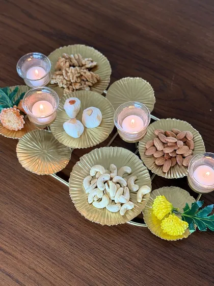 This unique gold-leaf platter features multiple sections for serving an assortment of nuts and sweets, with integrated T-light holders to add a warm glow. It’s a perfect centerpiece for festive gatherings.