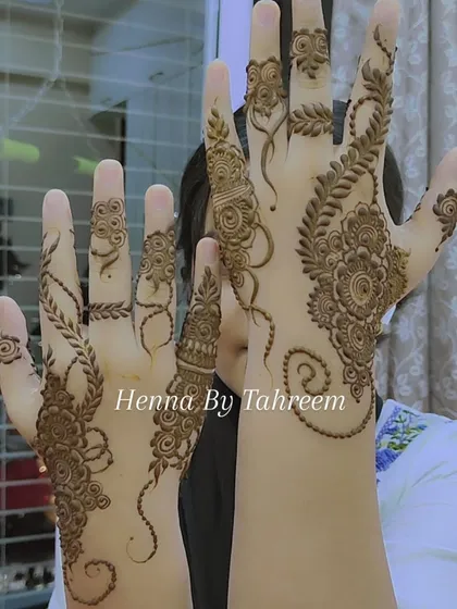 A beautiful example of a modern, asymmetrical henna design. One hand features a delicate vine, while the other has a fuller floral bunch, creating a unique and stylish pairing.