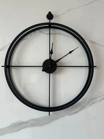 A classic minimalist design, this large 24-inch metal wall clock features a simple double-ring frame in an antique black finish. Its clean lines and open face make it a versatile piece that complements any decor style, from modern to industrial.