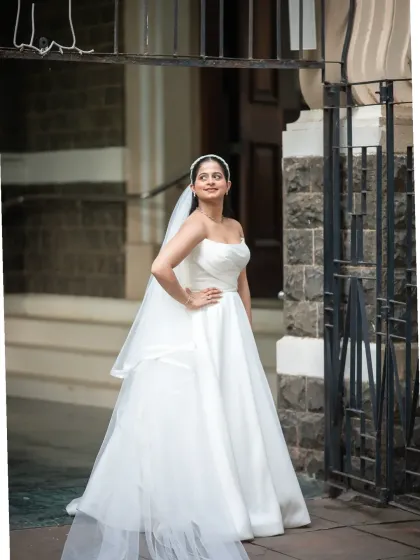 A stunning full-length portrait of the bride outside a classic Mumbai church. Her elegant pose and beautiful dress make for a timeless wedding photo.