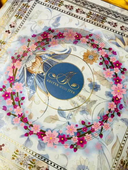 A close-up of the lid, showcasing the three-dimensional quality of the floral wreath made from decorative gems. The couple's monogram sits in the center, creating a beautiful and personal focal point for this luxury invitation.