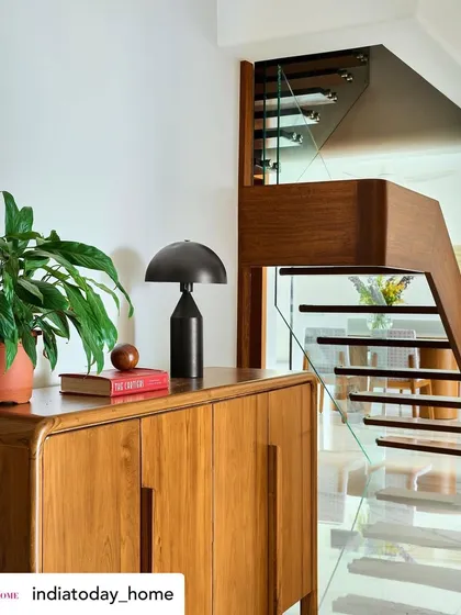 A detail shot of the custom wooden cabinetry and staircase with a glass railing. This showcases our use of warm teak wood and modern elements to create functional pieces that are also works of art.