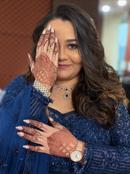 A creative shot that showcases both the intricate mehendi and the soft, beautiful makeup.