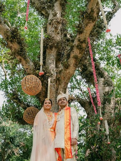 The couple poses under a magnificent old tree, which we decorated with hanging floral strings and rustic wicker balls.