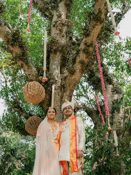 The couple poses under a magnificent old tree, which we decorated with hanging floral strings and rustic wicker balls.
