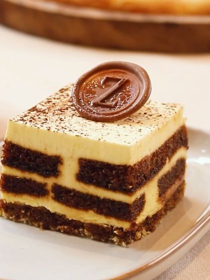 A perfect slice of my Tiramisu, showcasing the distinct layers of coffee-soaked sponge and creamy mascarpone, topped with my 'Z' chocolate seal.