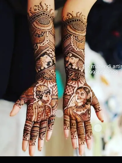 A clear and detailed portrait of the bride and groom. The arms are decorated with elephant motifs and traditional patterns.