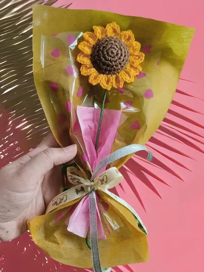 A single crochet sunflower wrapped with bright yellow and pink paper. We love playing with colors to make each gift feel unique and cheerful.
