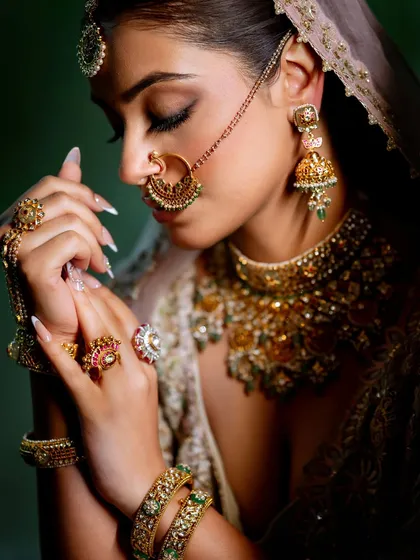 A detailed shot focusing on the hands, jewelry, and the soft, closed-eye makeup. Every element is styled to perfection for an editorial feel.