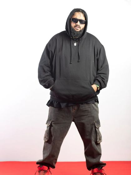 A studio portrait of Rapper All OK, capturing his confident and relaxed vibe.