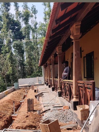The modernization of a traditional estate bungalow in Sakleshpur, showing the early stages of landscape work. The design includes a new veranda that will overlook the planned gardens, connecting the rustic architecture to its natural setting.