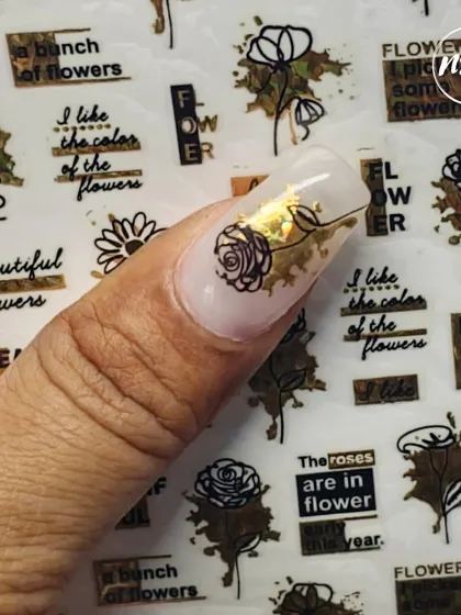 Our students learn to work with various materials, including these trendy nail art stickers. Here, a student has expertly combined a floral sticker with gold foil for a quick yet elegant design.