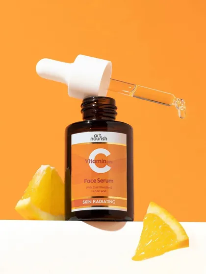 A simple yet effective composition. The Vitamin C serum bottle is propped up with fresh orange wedges, instantly connecting the product to its key ingredient and benefit. The clean lines keep it feeling modern.