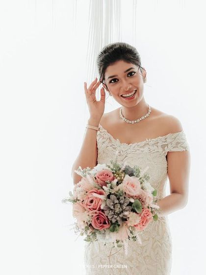 A bright, high-key portrait of the bride, her happy smile the central focus against a clean white background.