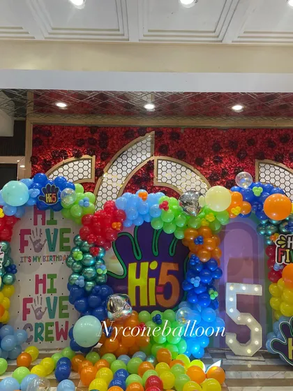 The full stage view of the 'Hi-5' birthday setup. The combination of the colorful balloon pit, themed backdrops, and a light-up number '5' creates an immersive and exciting party environment.