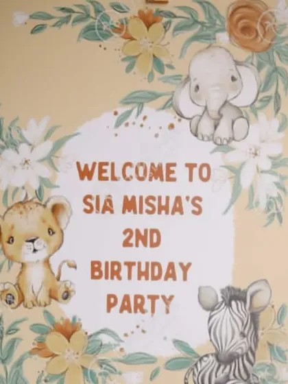A close-up of the welcome sign for Sia and Misha's jungle-themed second birthday party. The cute, illustrated baby animals perfectly matched the gentle and fun "Wild One" vibe.