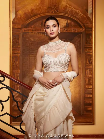 The Kairi Saree Set, draped in opulence. The intricate high-neck blouse and flowing ruffles tell a tale of pure luxury.