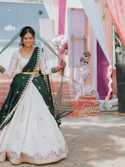 The bride playfully posing with her veil, showcasing the beautiful details of her Haldi ceremony attire.