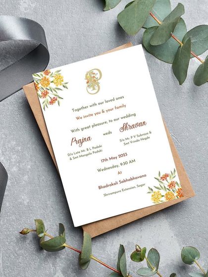 A beautiful and simple printed wedding invitation with a marigold watercolor theme. The warm yellow and orange flowers add a touch of traditional sunshine, perfect for a classic Indian wedding ceremony.