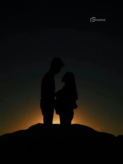 A dramatic silhouette of a couple against a setting sun, creating a powerful and emotional image.