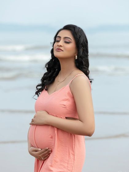 A beautiful close-up, with her eyes closed, enjoying the moment. The ocean in the background adds a sense of calm and timelessness.
