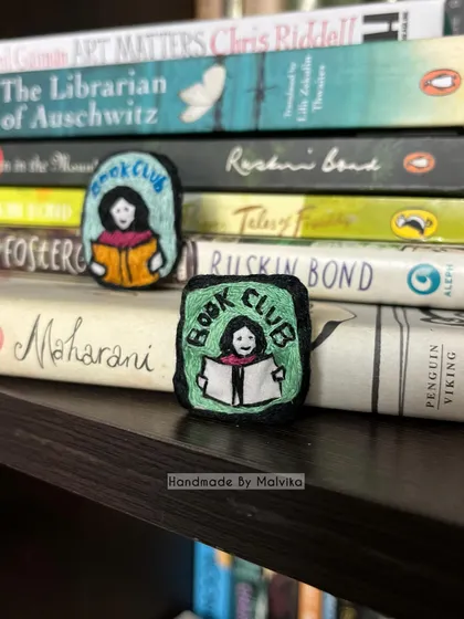 As a book lover myself, I had to create something for my fellow readers. I've placed these 'Book Club' badges right where they belong, among some of my favorite stories. It’s the perfect embroidered pin to add a literary touch to your jacket or tote bag.