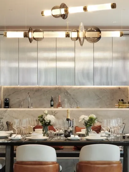 The Luna series provides elegant illumination over a formal dining table. The combination of illuminated tubes and decorative glass elements adds a layer of glamour and sophistication.