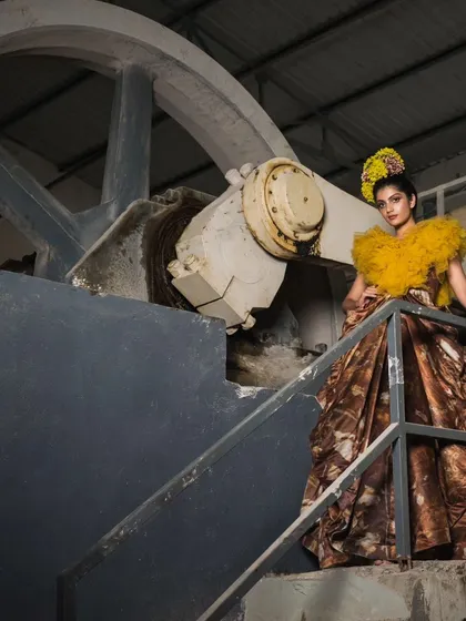 A creative composition from the marble factory shoot, using industrial machinery as a framing device. The contrast between the soft yellow tulle and the hard metal creates a compelling visual story.