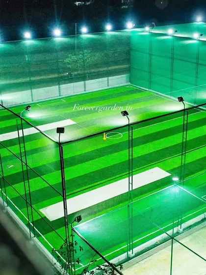 A well-lit cricket practice facility at night, featuring multiple pitches with high-quality artificial grass for consistent performance.