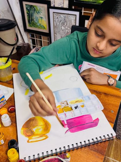 A student in our elementary batch works on her metal painting. You can see her mixing colors on the palette to get the right tones for the highlights and mid-tones of the objects.