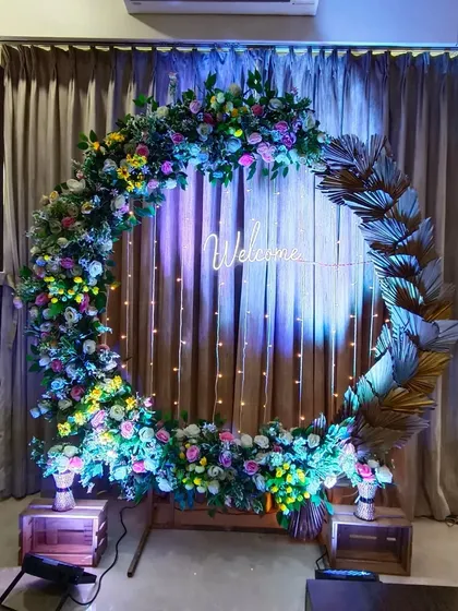 A full circular floral arch with a "Welcome" neon sign. This versatile piece is perfect as a photo backdrop or an entrance for any celebration.