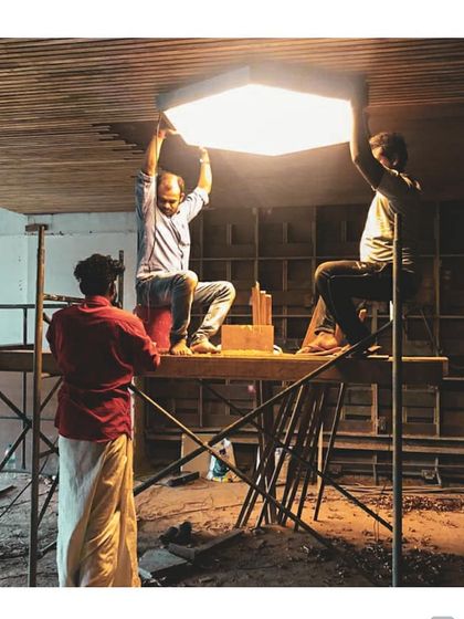 Our team on-site, installing a custom-made hexagonal light fixture for a cafe in a luxury hotel. This image shows the collaborative, hands-on effort required to execute complex design elements.
