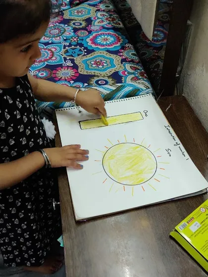 A snapshot from a live online session where a student is learning about the number one by coloring a big yellow sun. I use interactive worksheets and coloring to keep children focused and engaged, even through a screen.